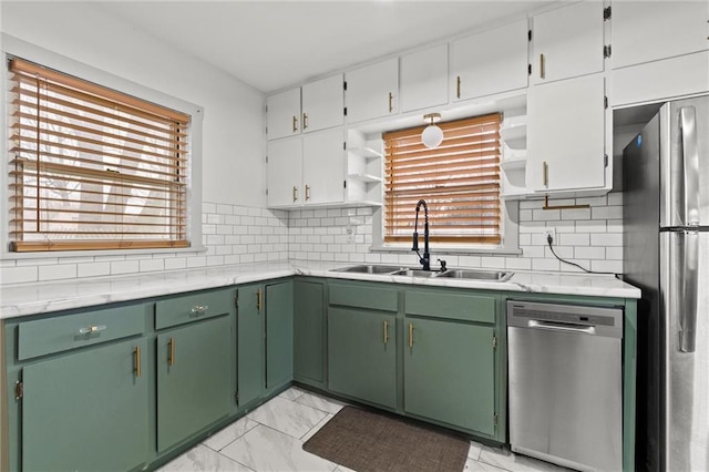 kitchen featuring white cabinetry, stainless steel appliances, sink, and backsplash