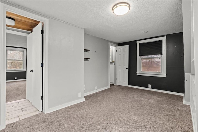 carpeted empty room with a textured ceiling