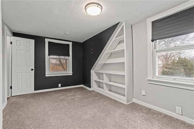 carpeted empty room featuring a textured ceiling