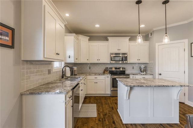 kitchen featuring appliances with stainless steel finishes, a center island, sink, and white cabinets