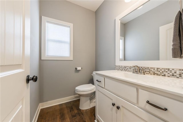 bathroom with vanity, toilet, hardwood / wood-style floors, and decorative backsplash