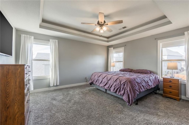 bedroom with carpet flooring, ornamental molding, and a tray ceiling