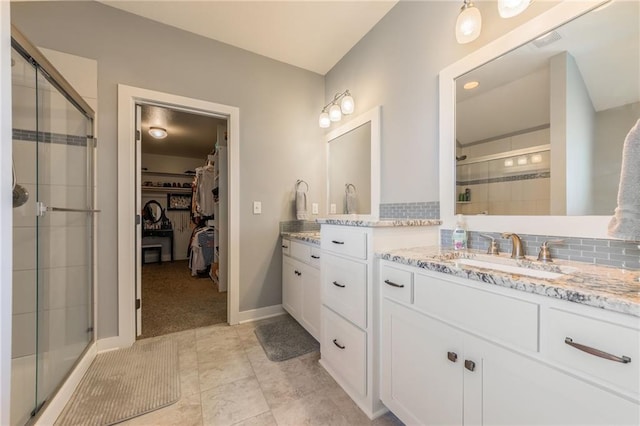 bathroom featuring vanity, an enclosed shower, and decorative backsplash