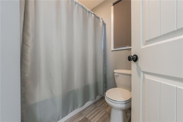 bathroom featuring toilet and walk in shower