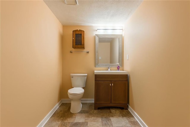 bathroom featuring vanity, toilet, and a textured ceiling