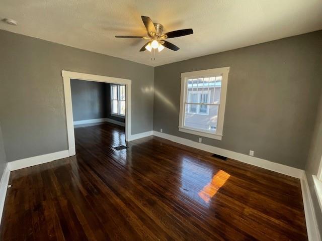 empty room featuring dark hardwood / wood-style floors and ceiling fan