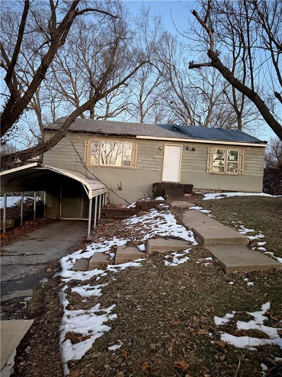 view of snowy exterior with a carport