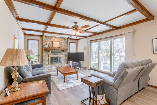 living room with a fireplace, coffered ceiling, ceiling fan, light hardwood / wood-style floors, and beam ceiling