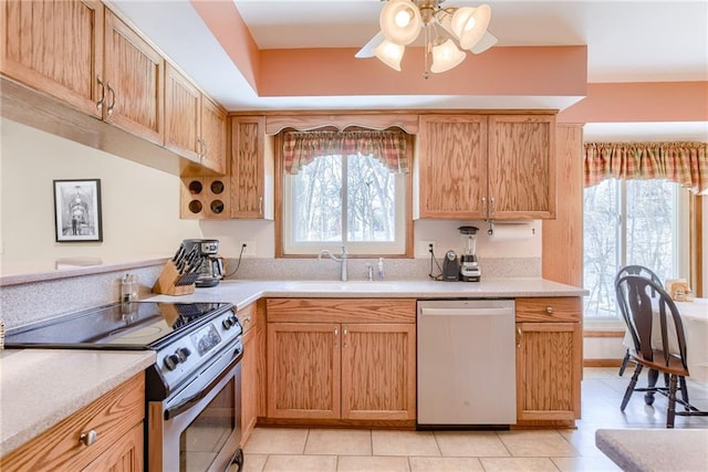 kitchen with ceiling fan, stainless steel appliances, sink, and light tile patterned floors