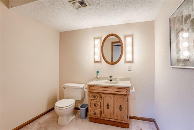 bathroom with vanity, a textured ceiling, and toilet