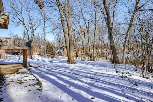 snowy yard featuring a wooden deck