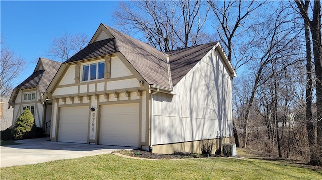 exterior space with roof with shingles, concrete driveway, and a front yard