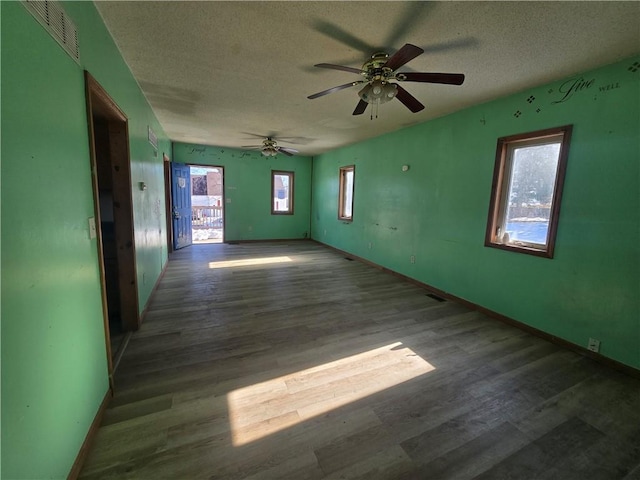 spare room featuring wood-type flooring, a healthy amount of sunlight, and a textured ceiling