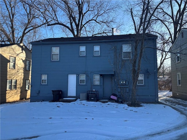 view of snow covered back of property