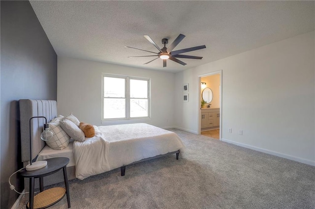 carpeted bedroom featuring ceiling fan, ensuite bathroom, and a textured ceiling