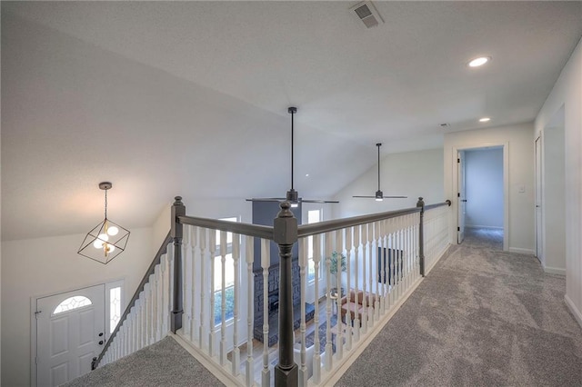 hallway featuring lofted ceiling and carpet flooring