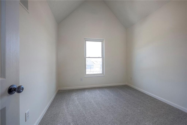 empty room with vaulted ceiling and carpet