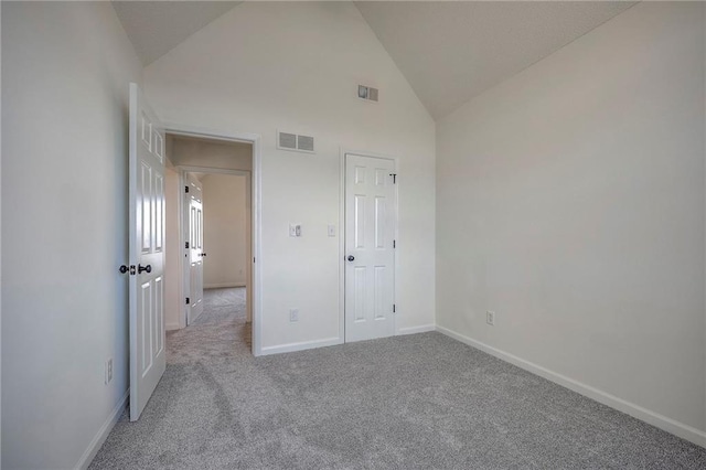 unfurnished bedroom featuring high vaulted ceiling and light carpet