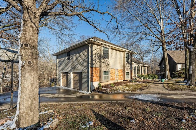 view of property exterior with driveway and an attached garage