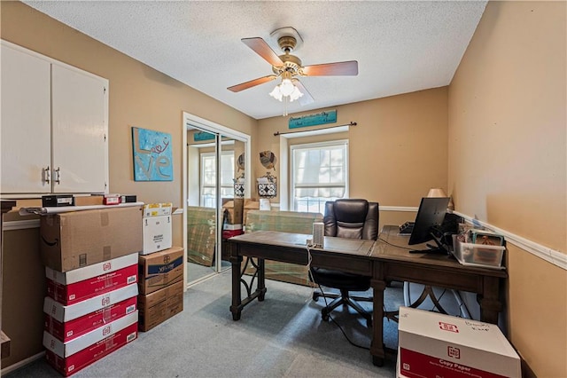 home office with light colored carpet, ceiling fan, and a textured ceiling