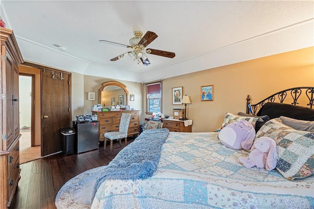 bedroom featuring hardwood / wood-style flooring, fridge, and ceiling fan