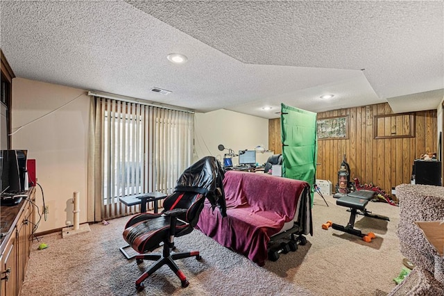 interior space with wood walls, baseboards, visible vents, and a textured ceiling