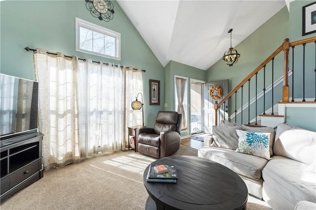 living room with carpet, high vaulted ceiling, and a chandelier