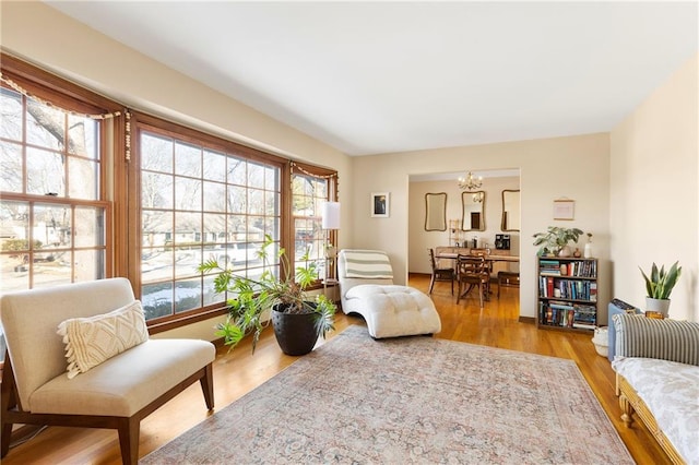 living area featuring a notable chandelier and light wood-type flooring