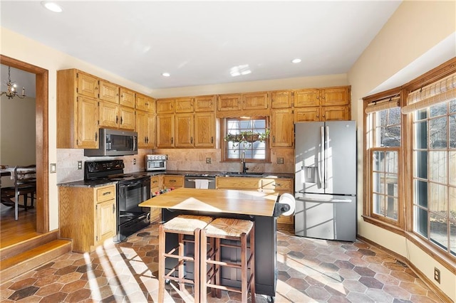 kitchen featuring tasteful backsplash, sink, a kitchen breakfast bar, and appliances with stainless steel finishes