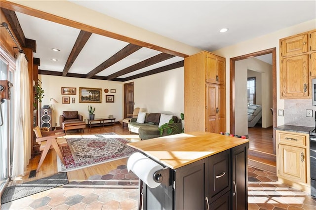 kitchen with beam ceiling, light brown cabinetry, light hardwood / wood-style floors, and decorative backsplash