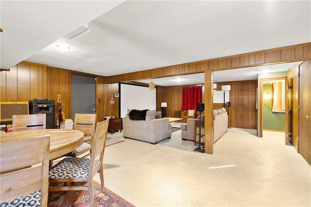 carpeted dining space featuring wooden walls