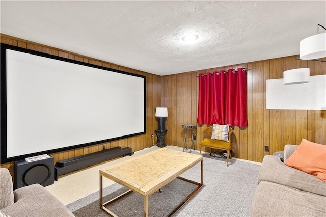 home theater room featuring wooden walls, carpet flooring, and a textured ceiling