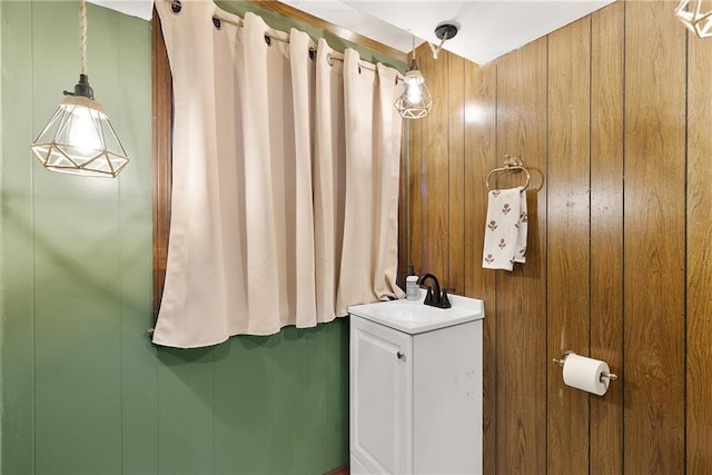 bathroom with vanity and wooden walls