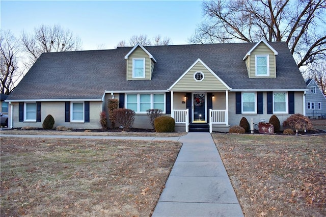 cape cod-style house with covered porch