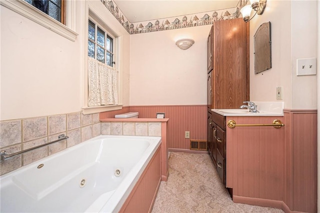 bathroom with a washtub, vanity, and wood walls