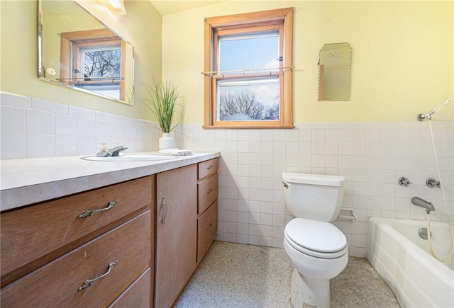 bathroom with a tub to relax in, vanity, toilet, and tile walls