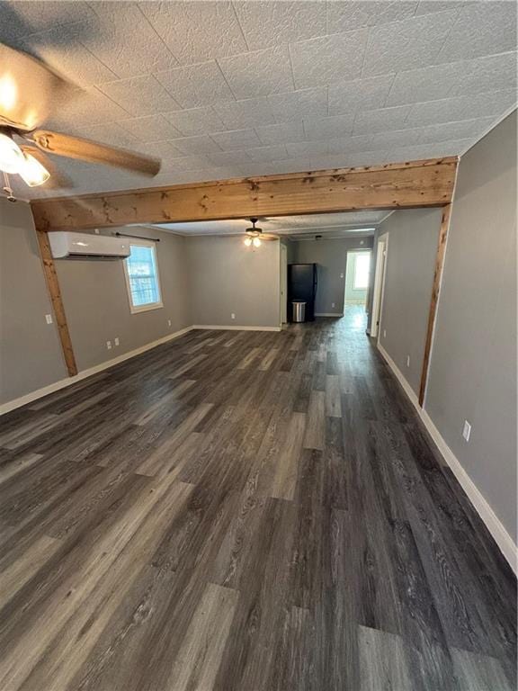 interior space featuring beamed ceiling, ceiling fan, a wall unit AC, and dark hardwood / wood-style flooring