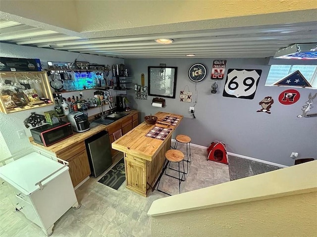 bar with wooden counters, dishwasher, and sink