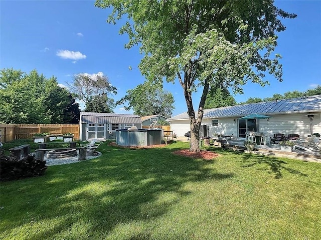 view of yard featuring a pool, an outdoor structure, and a patio