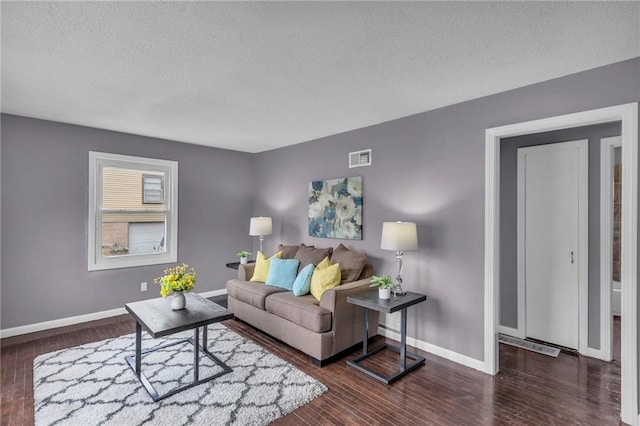 living room with dark hardwood / wood-style floors and a textured ceiling