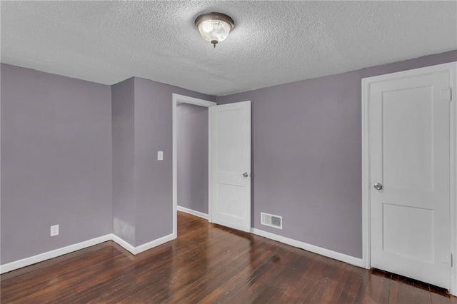 unfurnished room featuring dark hardwood / wood-style floors and a textured ceiling