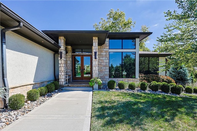 entrance to property with french doors and a yard