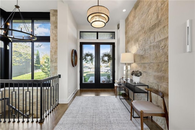 foyer featuring an inviting chandelier, hardwood / wood-style flooring, french doors, and a high ceiling