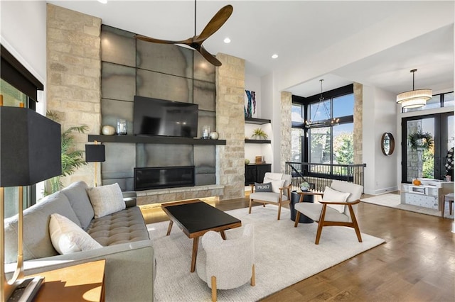 living room featuring a fireplace, wood-type flooring, and a chandelier