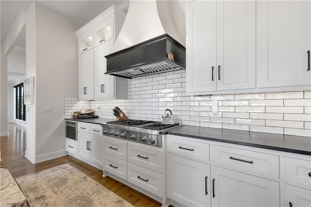 kitchen featuring premium range hood, tasteful backsplash, white cabinets, dark hardwood / wood-style flooring, and stainless steel gas stovetop