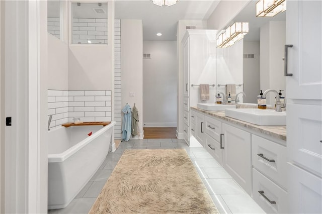 bathroom featuring tile patterned floors, a tub to relax in, and vanity