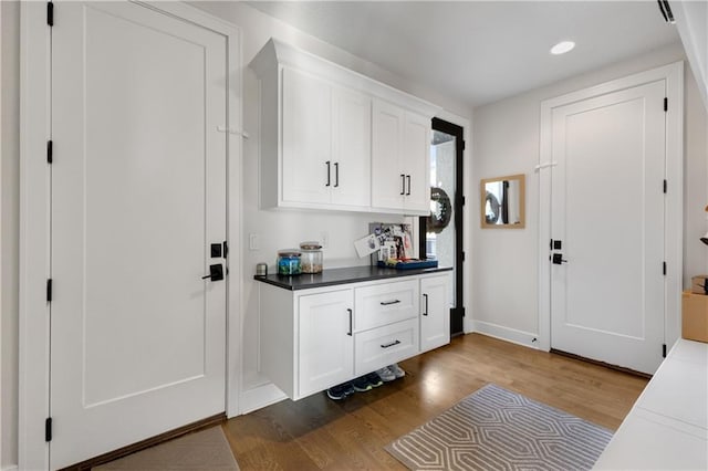 interior space with dark hardwood / wood-style flooring and white cabinets