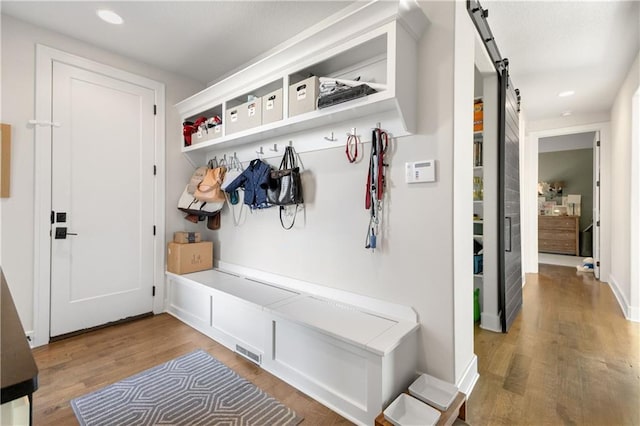 mudroom featuring wood-type flooring and a barn door