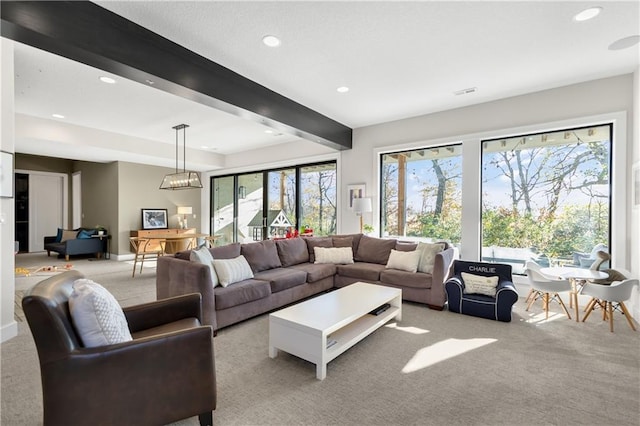 carpeted living room featuring beamed ceiling and plenty of natural light