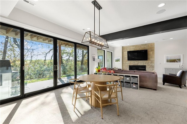 dining space with a large fireplace and beam ceiling